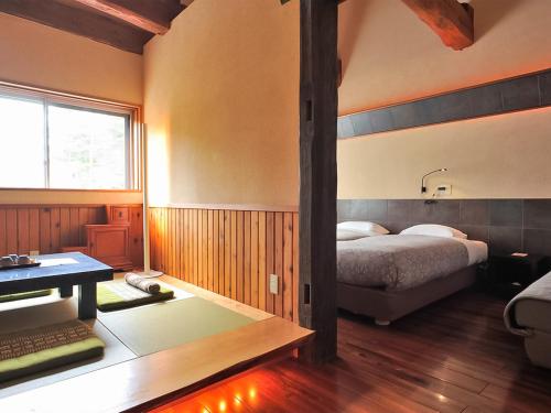 a bedroom with a bed and a desk in it at Kunugi Relaxation with 4 modern rooms in Hakuba