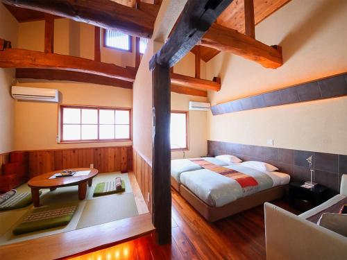 um quarto com uma cama, uma secretária e uma mesa em Kunugi Relaxation with 4 modern rooms em Hakuba