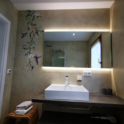 a bathroom with a white sink and a mirror at BB19 Eifel-Ferienhaus am Moseltal mit Saunahaus in Beuren