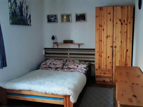 a bedroom with a bed and a wooden cabinet at Appartment, Wieliczka by Cracow in Wieliczka