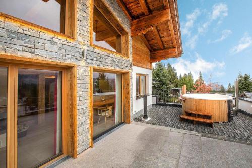 a house with a tub on a patio at Chalet in Königsleiten with Mountain Views & Spa in Königsleiten