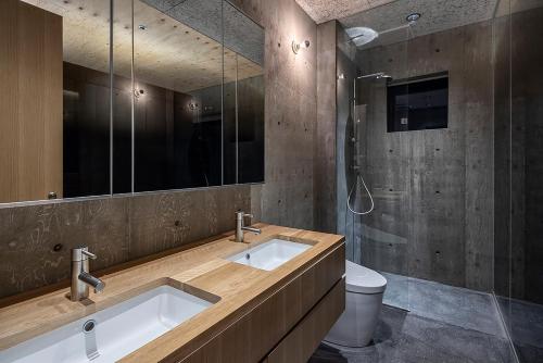 a bathroom with a sink and a toilet and a mirror at Puffin by H2 Life in Niseko