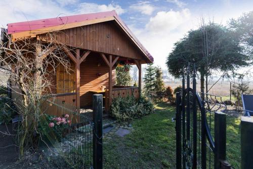 a small wooden building with a fence in a yard at holiday home in Domyslow by Kolczewo the perfect place for two guests in Kołczewo