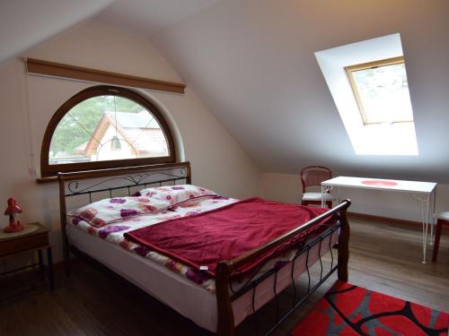 a bedroom with a bed and an attic window at holiday home, Swibno in Świbno