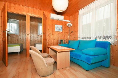 a living room with a blue couch and a table at Holiday resort, Wicie in Wicie