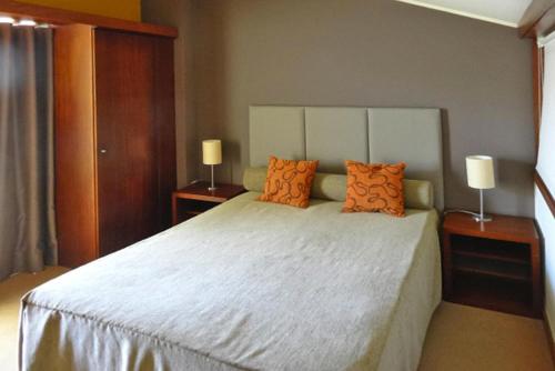 a bedroom with a large white bed with orange pillows at Holiday resort Clube Pinhal da Foz, Esposende, Studio for 2 pers in Esposende