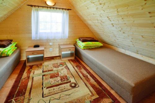 an attic room with two beds and a window at Holiday Home in Jaros awiec near Beach & Cliff in Jarosławiec