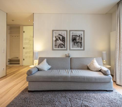 a living room with a gray couch in a room at Hapimag Ferienwohnungen Salzburg in Salzburg