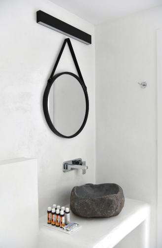 a bathroom with a mirror and a rock on a sink at 21 luxury apartments in Naousa