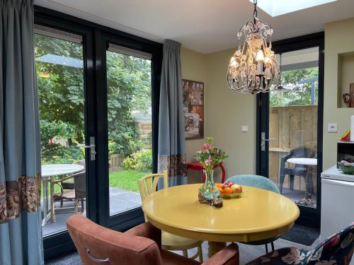 a dining room with a yellow table and chairs at B&B de Ruijsvogel in De Koog