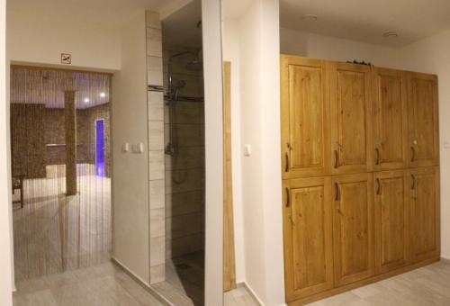 a bathroom with a shower and a wooden door at Relax pension Schonwald in Budišov nad Budišovkou