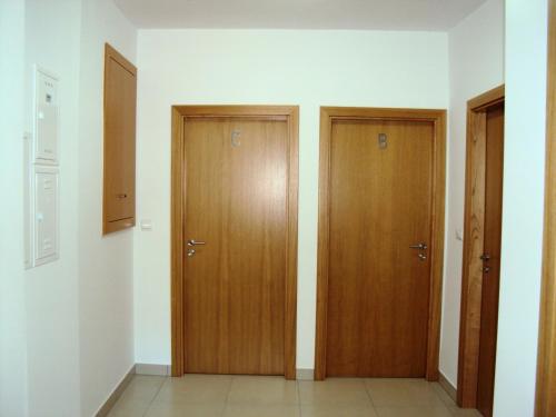 two wooden doors in a room with white walls at Casa do Mosteiro de Refoios do Lima in Ponte de Lima