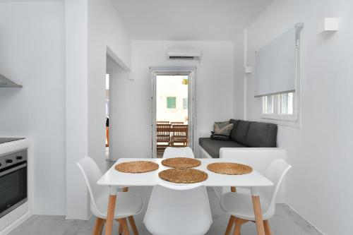 a white living room with a white table and chairs at 21 luxury apartments in Naousa