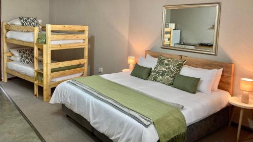 Aloe Cottage في نيلسبروت: غرفة نوم بسرير ومرآة وسلم