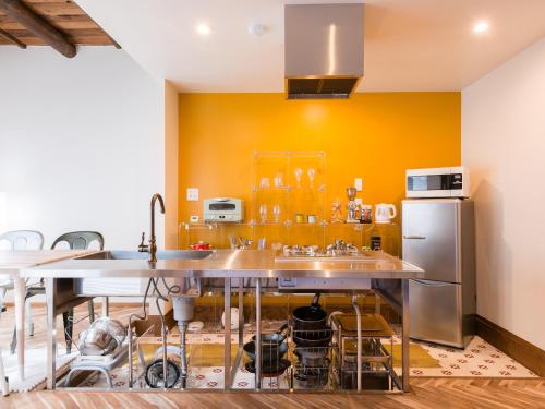 a kitchen with yellow walls and stainless steel appliances at Ryourizuki no Ie in Kyoto