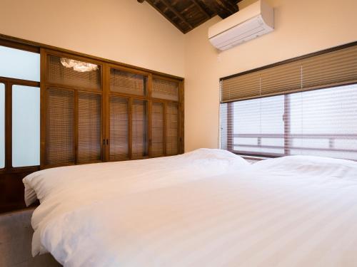 Un pat sau paturi într-o cameră la Ryourizuki no Ie
