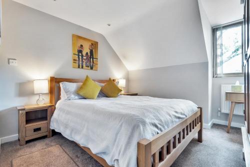 a bedroom with a large white bed with yellow pillows at Hamble Retreat Studios and Lodge in Warsash