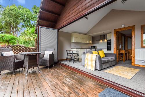 an outdoor deck with a couch and a table at Hamble Retreat Studios and Lodge in Warsash