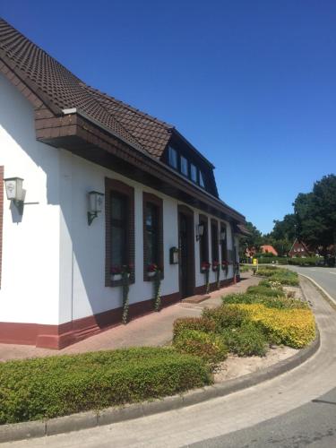 a white building with black windows and a street at Landgasthof Dockemeyer in Hollenermoor