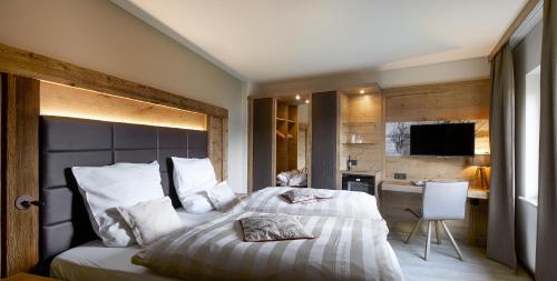 a bedroom with a large bed and a television at Hotel Bütgenbacher Hof in Butgenbach