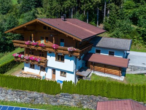 a house with a balcony with flowers on it at Cozy apartment with mountain views in Wald im Pinzgau