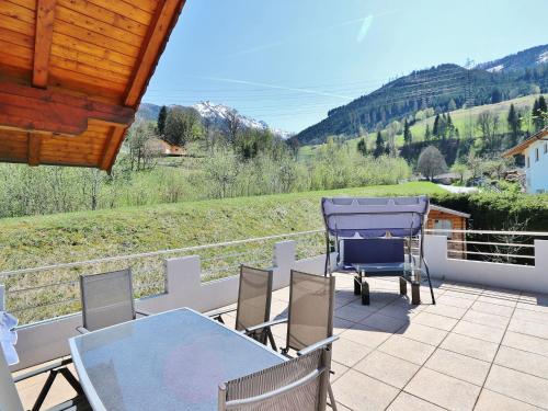 a patio with a table and chairs on a balcony at Apartment in Niedernsill with Private Terrace in Niedernsill