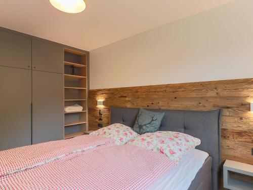 a bedroom with a bed with a wooden headboard at Chalet in Kirchberg near Ski Slopes in Kirchdorf in Tirol