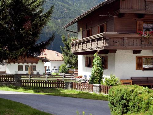 a house with a wooden fence in front of it at Apartment near the Otztal Arena ski area in Längenfeld