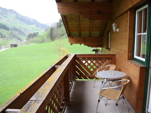 a balcony of a cabin with a table and chairs at Spacious Apartment in GroBarl with Sauna in Grossarl