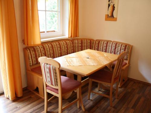 d'une salle à manger avec une table, des chaises et une fenêtre. dans l'établissement Spacious Apartment in GroBarl with Sauna, à Grossarl