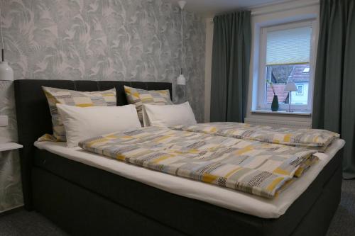 ein großes Bett in einem Schlafzimmer mit Fenster in der Unterkunft Harzapart Appartement 2 "Wandertraum" in Walkenried