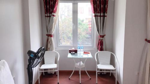 uma mesa e cadeiras num quarto com uma janela em GALAXY HOTEL Bắc Ninh em Bồ Sơn