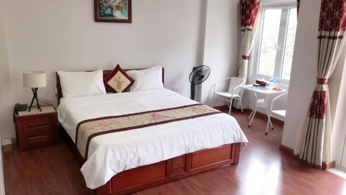 a bedroom with a bed and a table and a window at GALAXY HOTEL Bắc Ninh in Bồ Sơn