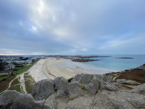 a view of a beach with rocks and the ocean at Résidence du Pélican in Lannion