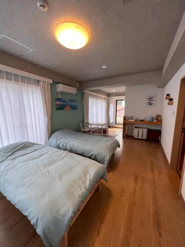 a bedroom with two beds and a kitchen in it at Upper Hotel Ishihara in Tokyo