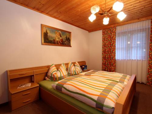 een slaapkamer met een bed en een houten plafond bij Serene Cottage in Neukirchen am Gro venediger in Neukirchen am Großvenediger