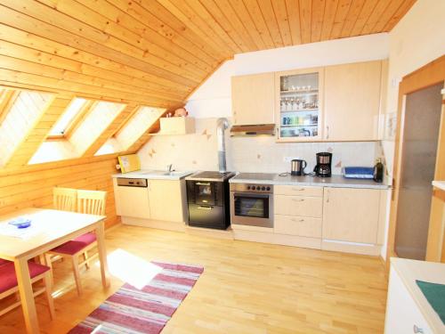 uma cozinha com uma mesa, um fogão e um balcão em Apartment in Koettmannsdorf near bathing lake em Wurdach