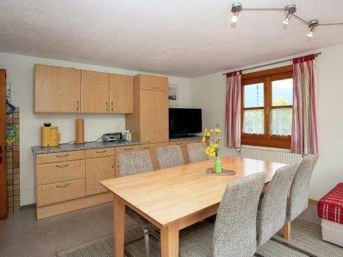 cocina y comedor con mesa de madera y sillas en Apartment in Tschagguns in Montafon, en Schruns