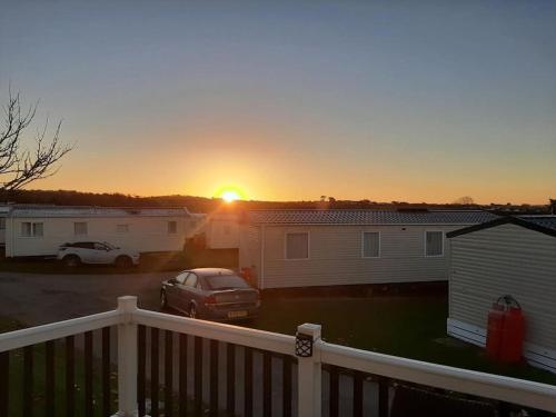 a car parked in a parking lot with the sunset in the background at Bude Coastal Lodge in Bude