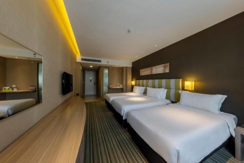 eine Reihe von Betten in einem Hotelzimmer in der Unterkunft Wanda YUE Changbaishan in Baishan