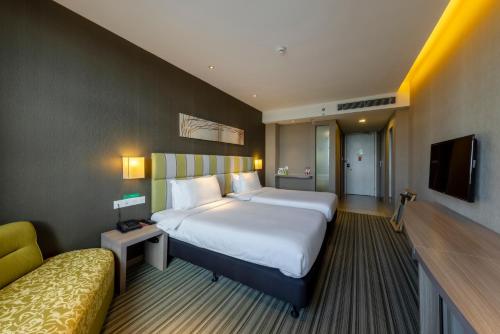 a hotel room with a large bed and a couch at Wanda YUE Changbaishan in Baishan