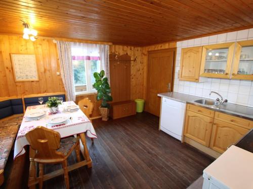 cocina con mesa y fregadero en Chalet in Prebl Carinthia with sauna near ski area, en Prebl