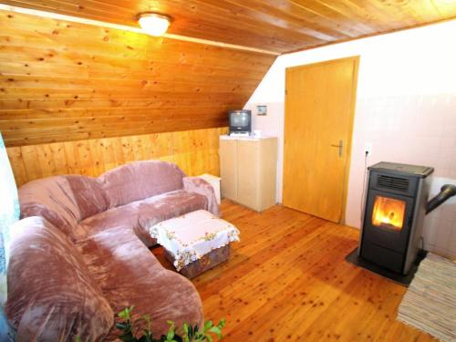 ein Wohnzimmer mit einem Sofa und einem Holzofen in der Unterkunft Chalet in Prebl Carinthia with sauna near ski area in Prebl