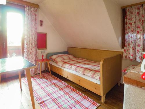 a small bedroom with a bed and a table at Spacious Alpine Hut in Bad Kleinkirchheim with Garden in Bad Kleinkirchheim