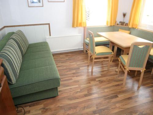 a living room with a green couch and a table at Holiday home in Bad Kleinkirchheim near ski area in Bad Kleinkirchheim