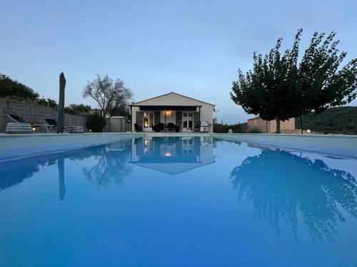 une piscine avec de l'eau bleue devant une maison dans l'établissement Villa Bonheur - Provence - Côte d'Azur, à Cabasse
