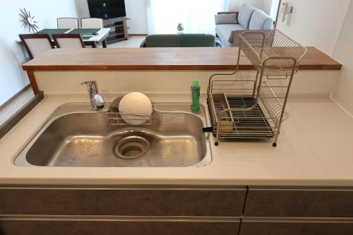 a kitchen sink with a dish drying rack in it at AP Yours 401 in Okinawa City