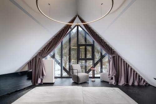 a room with a large window with a couch and chairs at Hotel Čad in Ljubljana