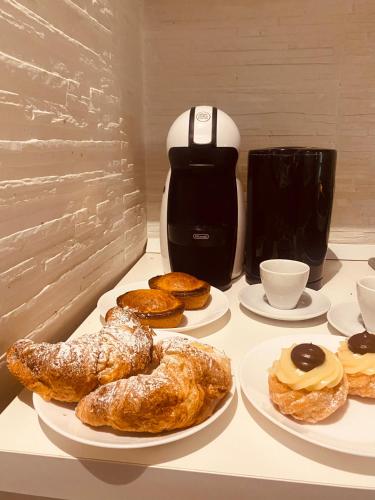 a table with plates of pastries and a coffee maker at Corte San Giorgio in Matino