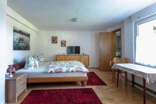 a bedroom with a bed and a table and a television at Bungalow am Wassergrundstück in Wendisch Rietz